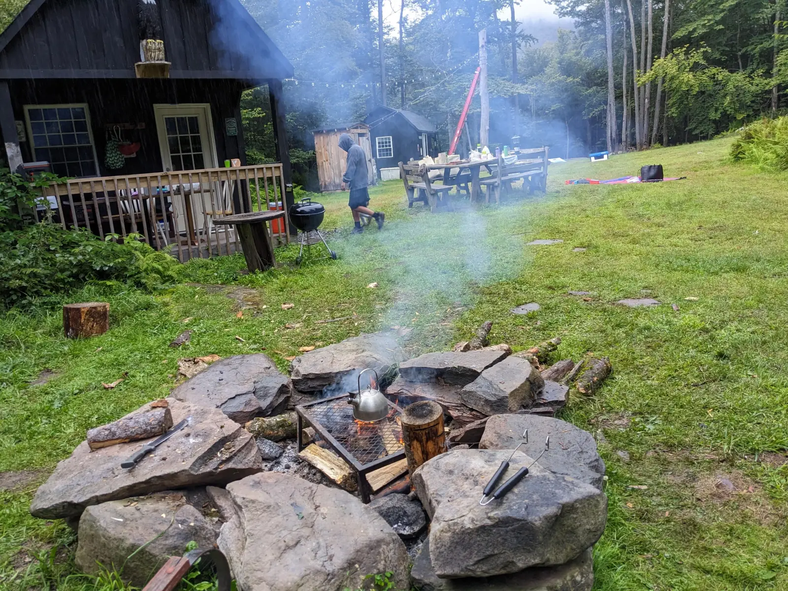 A kettle heating over a grate on a stone fire pit at the Catskills campsite